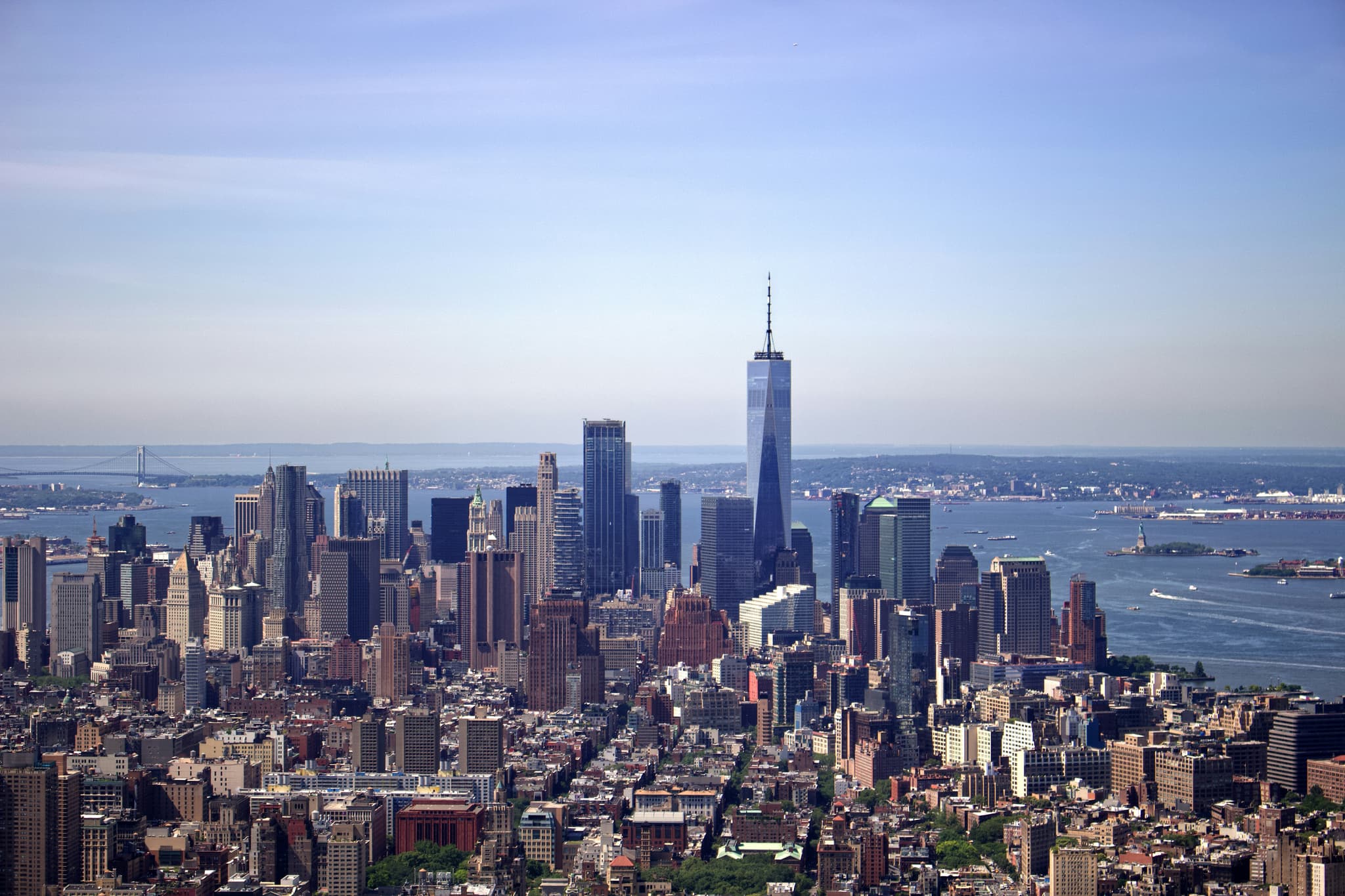 New York City skyline with iconic skyscrapers and the Statue of Liberty at dusk