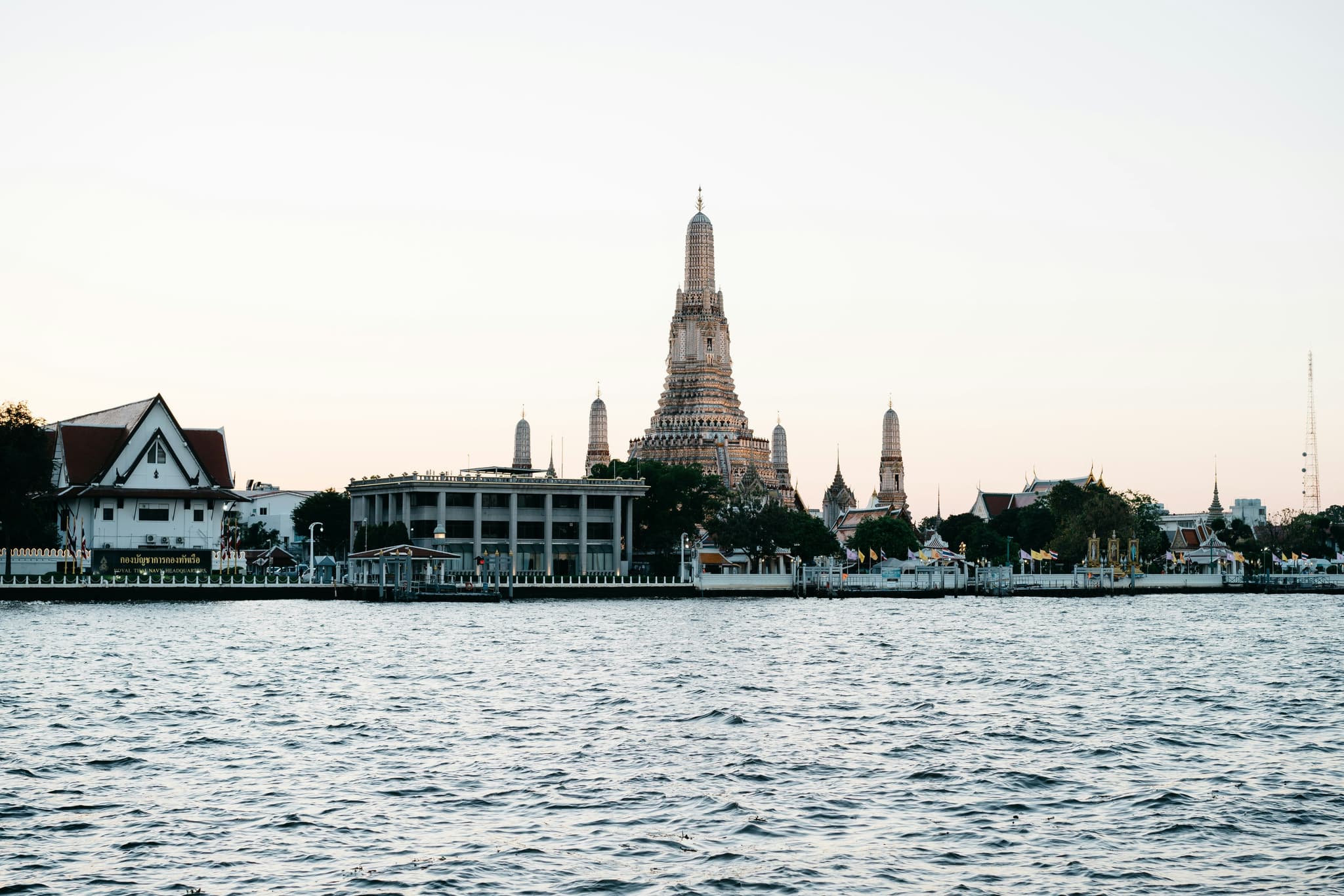 Bangkok skyline at dusk with Wat Arun temple and Chao Phraya River golden reflections