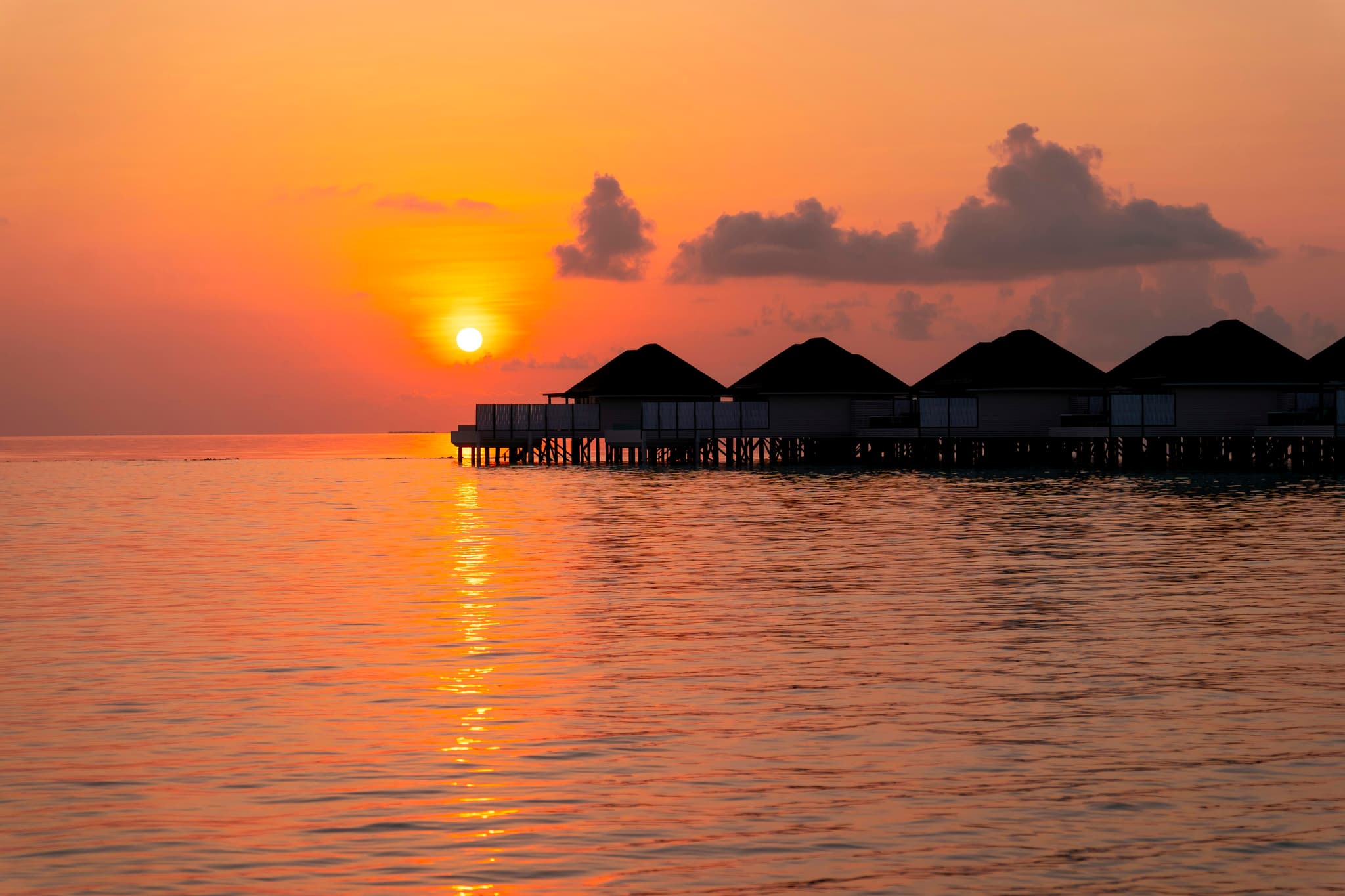 Romantic overwater villa at sunset in Thailand