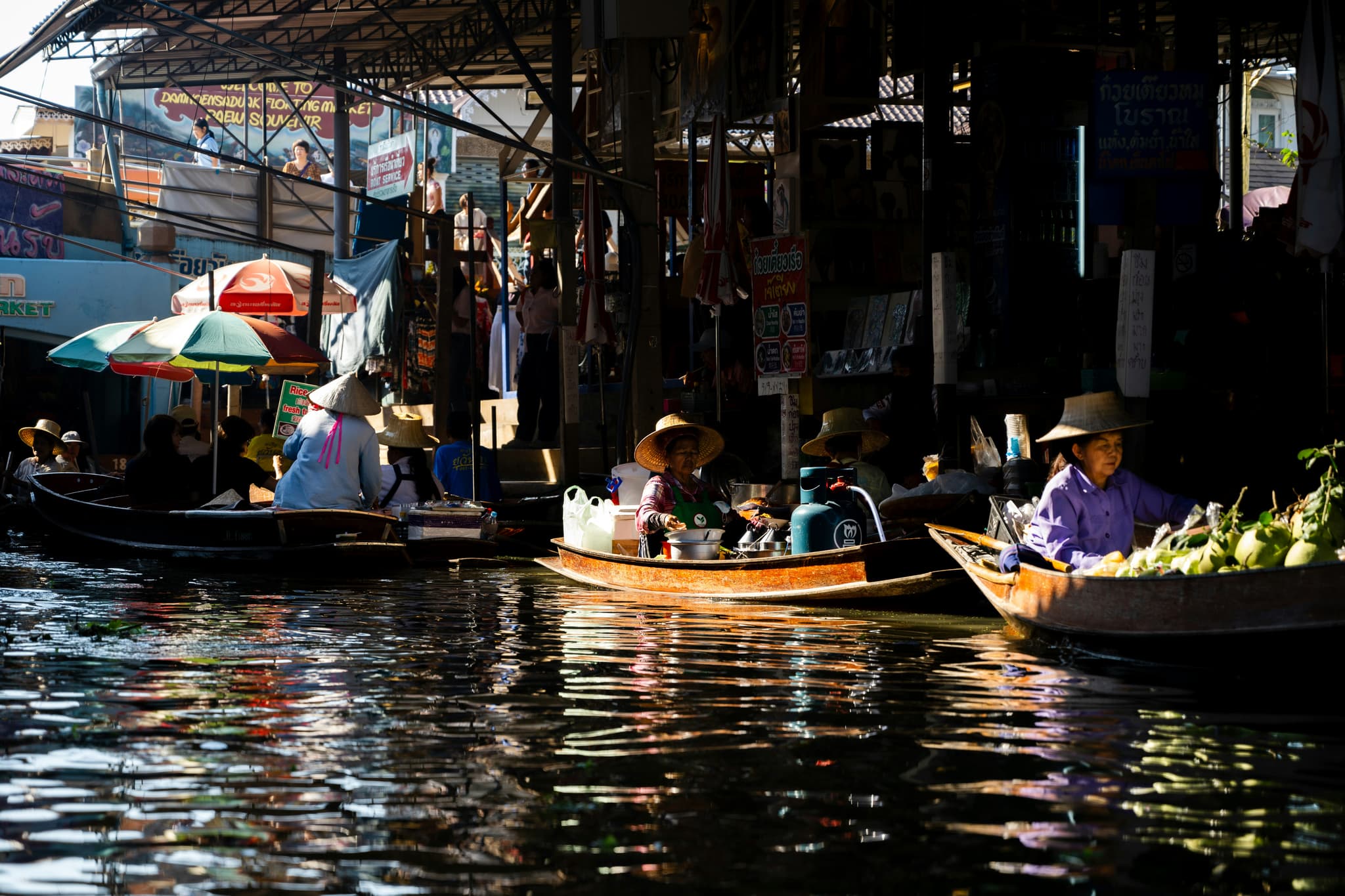 Colorful traditional Thai floating market with vendors selling fresh produce from wooden boats